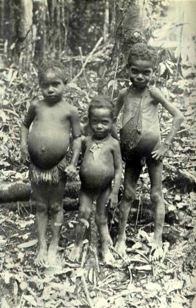 Трое маленьких детей из деревни Томбе слева девочка и справа два мальчика