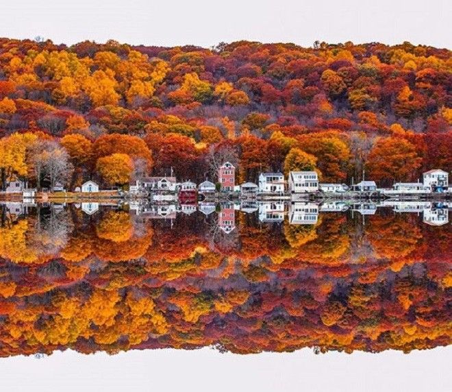 Яркий осенний пейзаж отражается в зеркально чистой воде без изъяна
