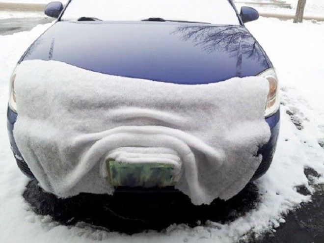 Слой снега покрыл бампер машины