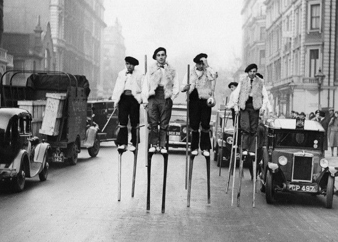 Танцоры на ходулях из ланд прогуливающиеся по улице Лондона по пути к Albert Hall 1937 год