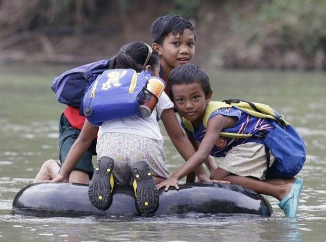 Дети в маленьком городке в Филиппинах добираются в школу вплавь