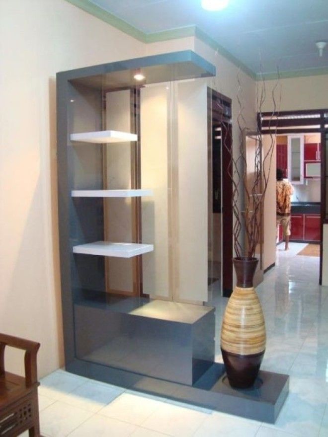 Современная гостиная комната в стиле минимализм с небольшим стеллажом нейтрального серого оттенка который максимально правильно разделяет пространство