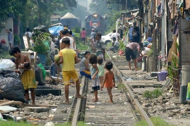 Филиппинские трущобы прямо вдоль железной дороги где буквально в метре от железнодорожных путей играют маленькие дети