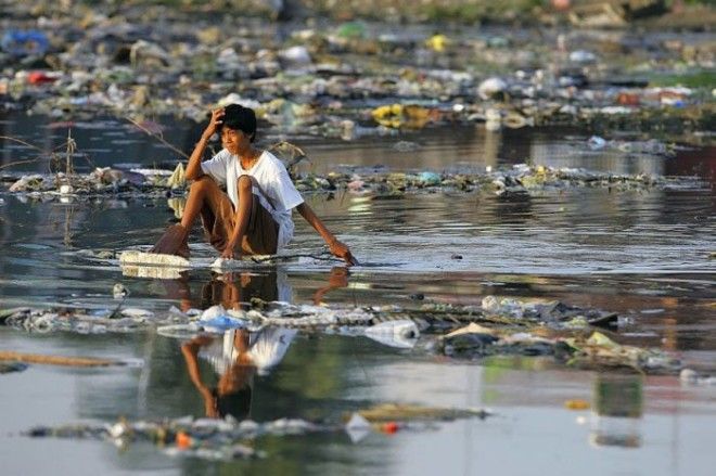 Филиппинский мальчик плывет по реке на куске пенопласта 