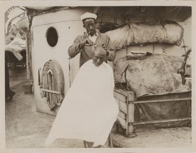 Афроамериканец бреет голову товарищу Фотография начала XX века 
