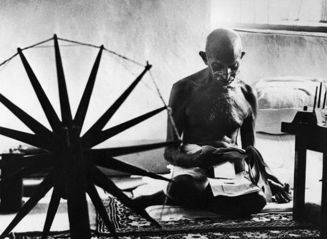 Махатма Ганди рядом с его прялкой - символом ненасильственного движения за независимость Индии от Великобритании.