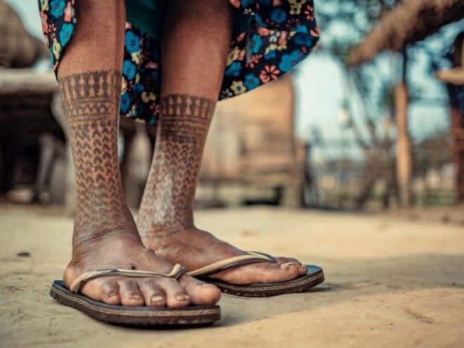 На ногах женщины татуировка в виде носочков